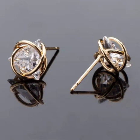 Anting stud wanita dengan hiasan simpul geometris berwarna emas, dihiasi zirkonia kubik (cubic zirconia).